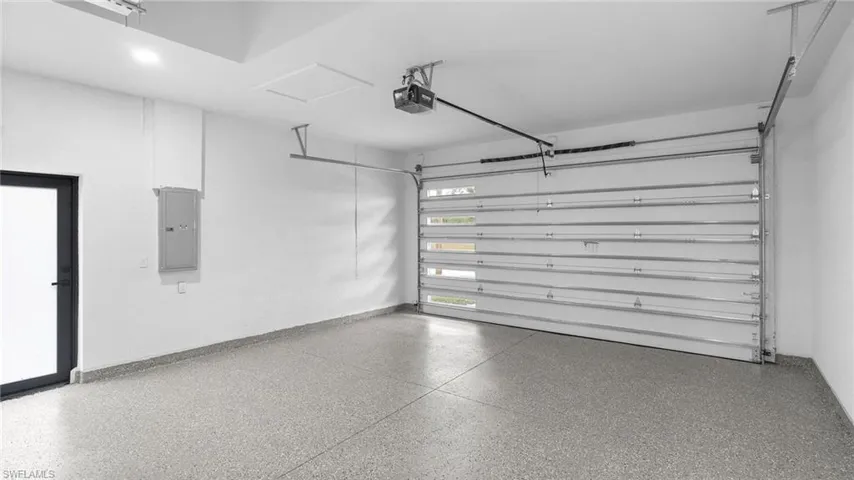 Garage featuring a garage door opener and electric panel