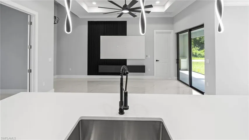 Kitchen view of a ceiling fan, recessed lighting, and light countertops