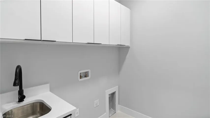 Washroom featuring cabinet space and hookup for a washing machine