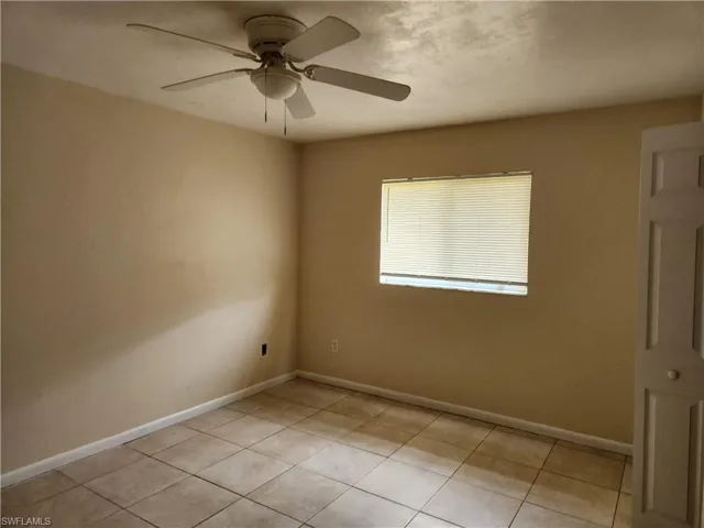 Empty room featuring light tile patterned floors and ceiling fan