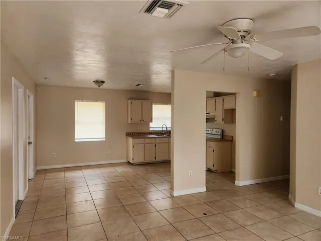Unfurnished living room featuring light tile patterned floors and ceiling fan
