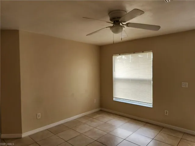 Empty room featuring light tile patterned floors and ceiling fan