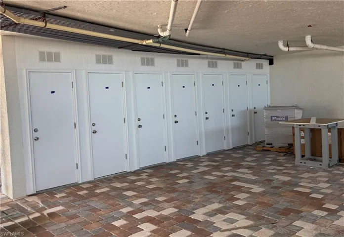 Garage area featuring brick floors and a textured ceiling