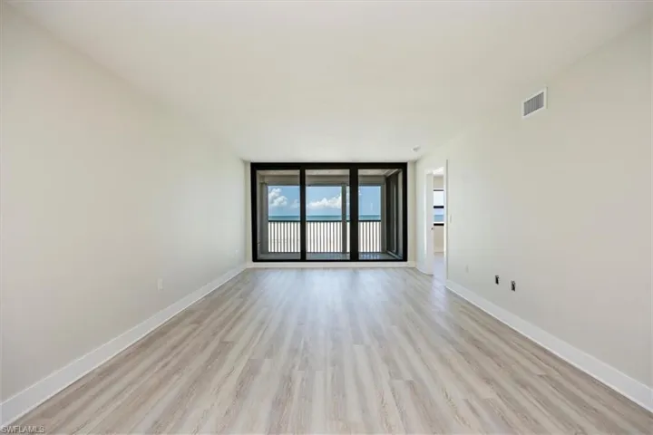 Living room with floor to ceiling windows and light wood-style floors