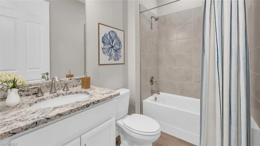 This image is virtually staged. Full bath featuring shower / bathtub combination with curtain, vanity, and light wood-type flooring