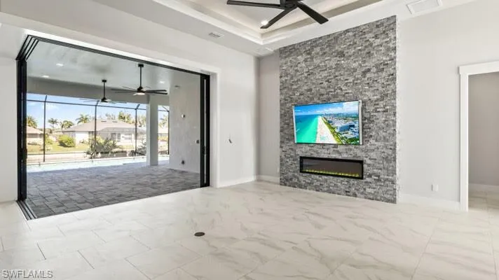 Great room with view towards lanai and pool area,featuring a fireplace.