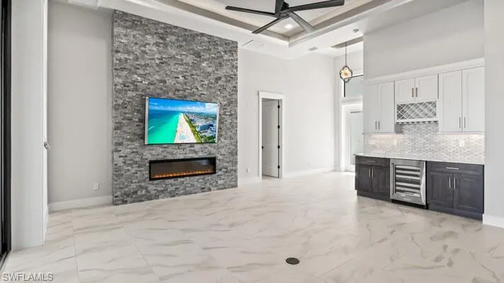 Living room area with view of the entryway ,bar area with wine fridge,