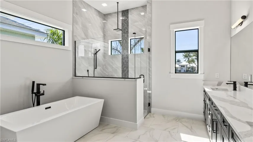 Bathroom with vanity, separate shower and tub, and a healthy amount of sunlight