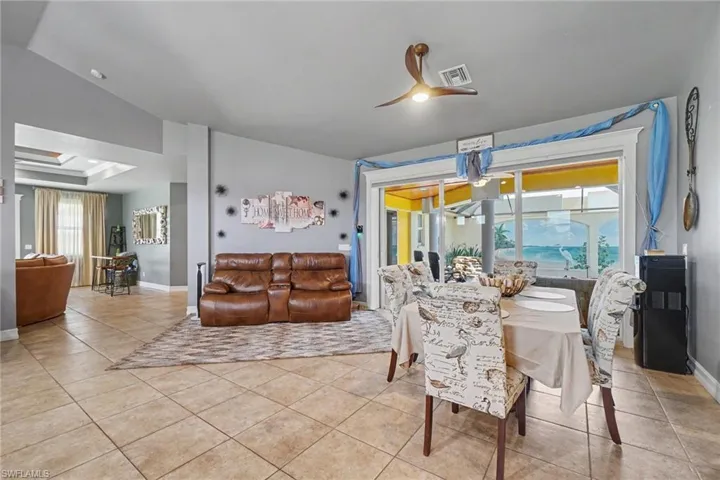 Spacious kitchen and entertaining area featuring a large center island, recessed lighting, tile flooring, and vaulted ceilings