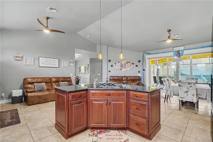 Central kitchen island featuring rich wood cabinetry and a dark stone countertop
