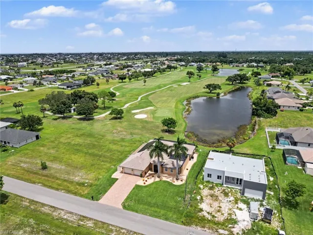 Aerial perspective featuring a single-family residence with a brick-paver driveway