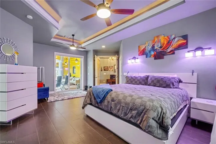 Spacious interior featuring wood-finish flooring, a tray ceiling with integrated lighting, and dual ceiling fans