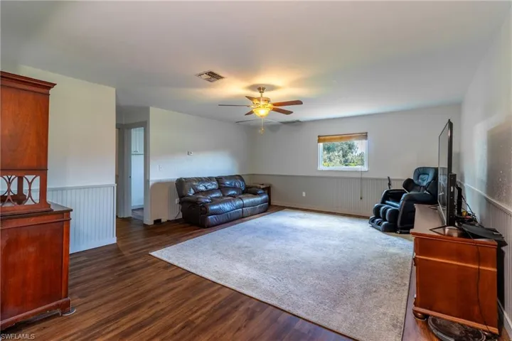Living room featuring dark hardwood / wood-style floors, radiator, and ceiling fan
