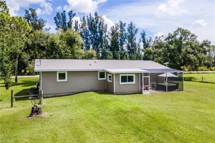 Back of house with a patio and a lawn