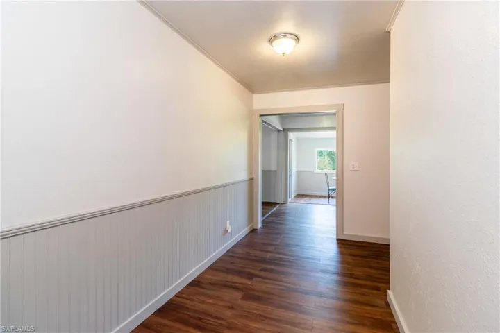 Corridor with crown molding and dark hardwood / wood-style floors