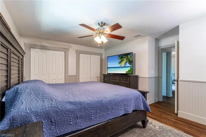 Bedroom featuring multiple closets, hardwood / wood-style flooring, and ceiling fan