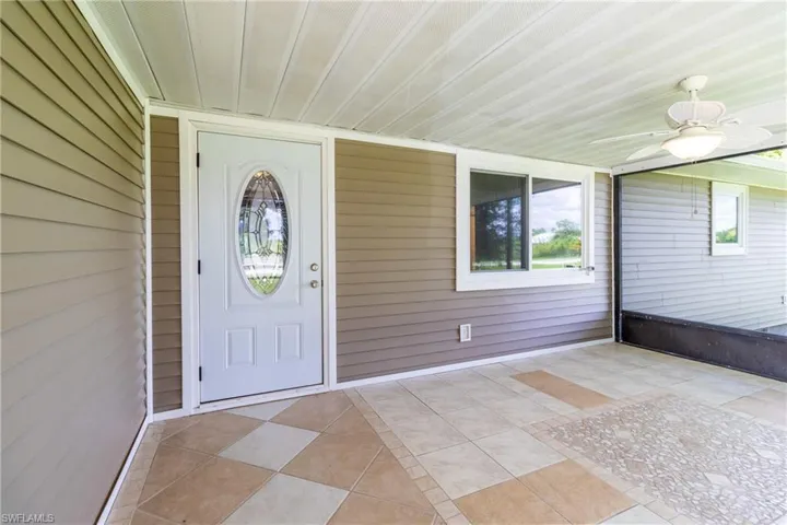Doorway to property with ceiling fan