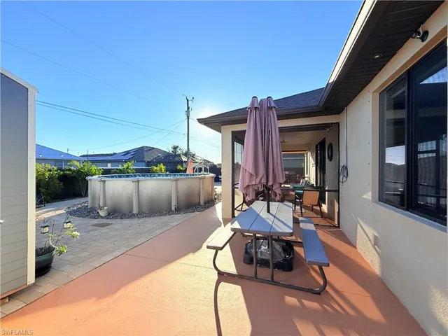 View of patio with outdoor dining area and a covered pool