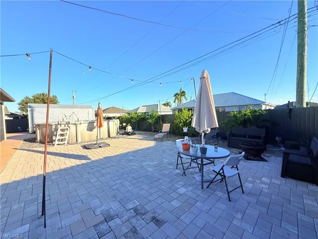 Fenced backyard featuring a patio, outdoor dining area, and an outdoor fire pit