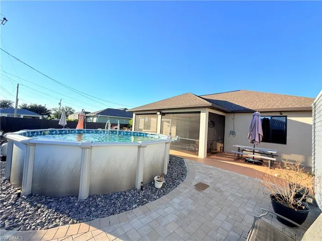 View of pool with a sunroom and a patio