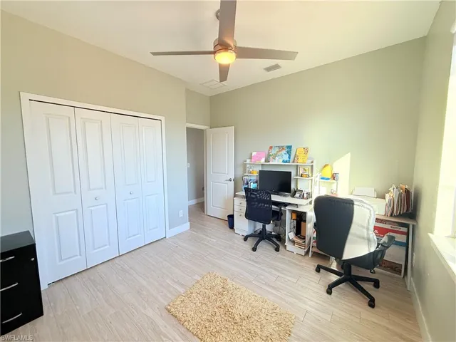 Office featuring light wood-type flooring and a ceiling fan