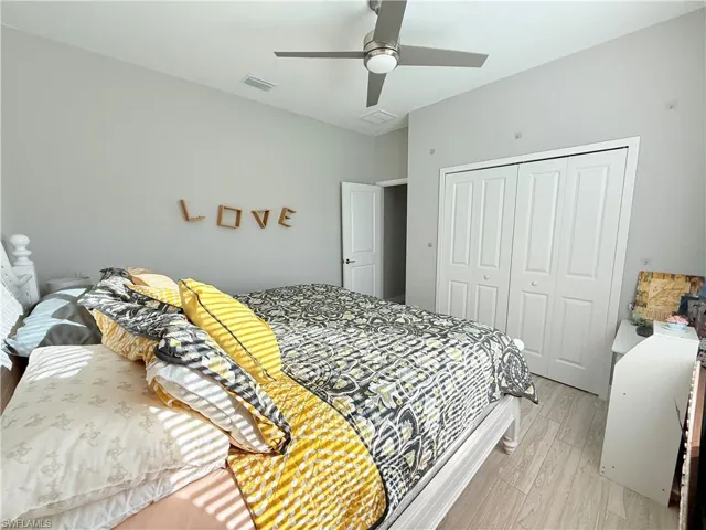 Bedroom with light wood-type flooring, a closet, and ceiling fan