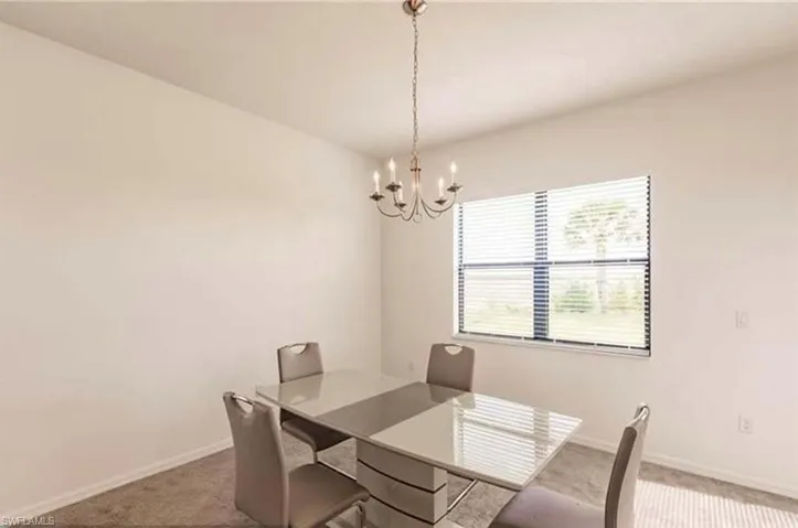 Dining area with carpet and a chandelier