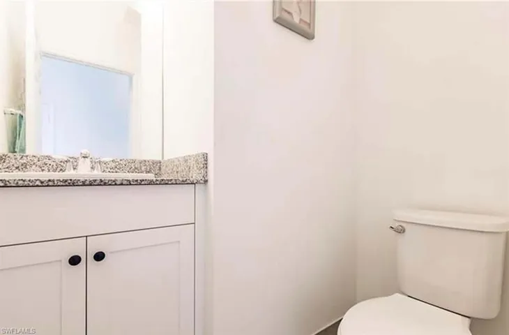 Half bathroom featuring vanity and toilet