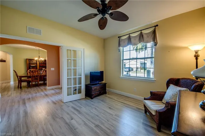 Sitting room featuring arched walkways, wood finished floors, suspended lighting, ceiling fan, and lofted ceiling