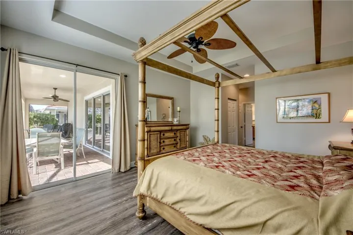 Bedroom featuring wood finished floors, access to outside, ceiling fan, and a sunroom