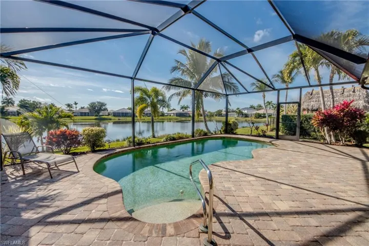 Swimming pool with a residential view, glass enclosure, a patio, and a sunroom