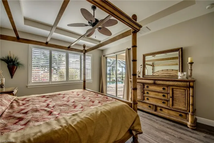 Bedroom featuring access to outside, dark wood-type flooring, and a ceiling fan