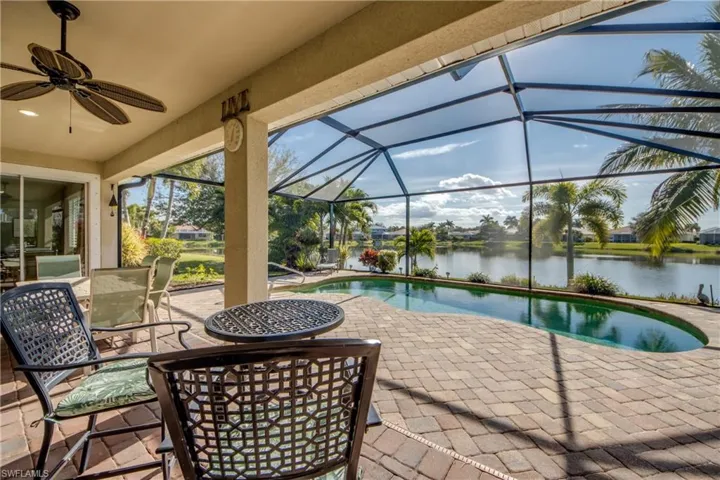 View of patio / terrace featuring a sunroom, an outdoor pool, a lanai, ceiling fan, and a water view