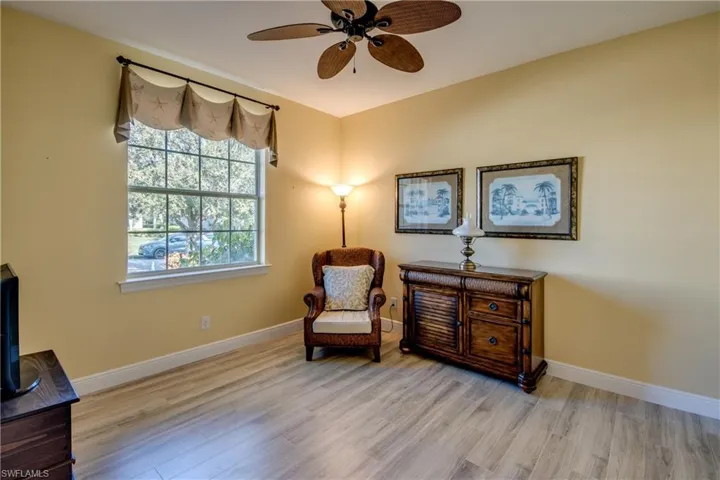 Sitting room with light wood-type flooring and ceiling fan
