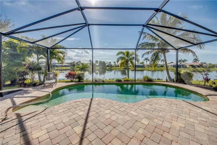 Outdoor pool featuring a sunroom, a lanai, a water view, and a patio