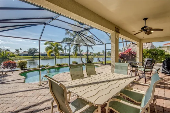 View of patio with a lanai, a ceiling fan, a residential view, a sunroom, and outdoor dining space
