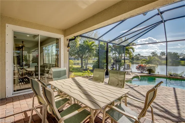 Sunroom / solarium with a patio, a water view, and outdoor dining space