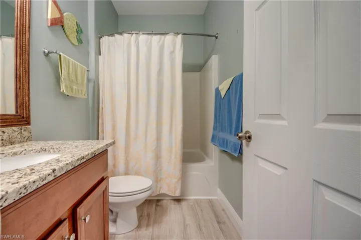 Bathroom featuring light wood-style flooring, vanity, and shower / tub combo