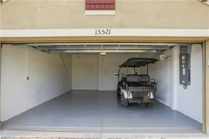 Attached garage featuring an epoxy-coated floor, electrical subpanel, and an overhead automatic door opener