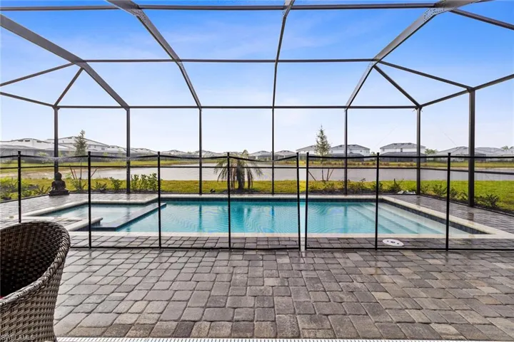 Screened lanai featuring a swimming pool, integrated spa, and paver decking