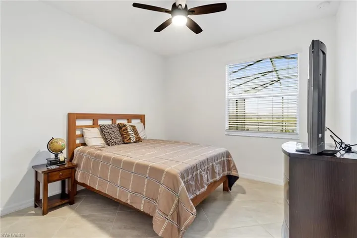 Bright room featuring a ceiling fan with integrated lighting, a window with horizontal blinds, and light-toned tile flooring