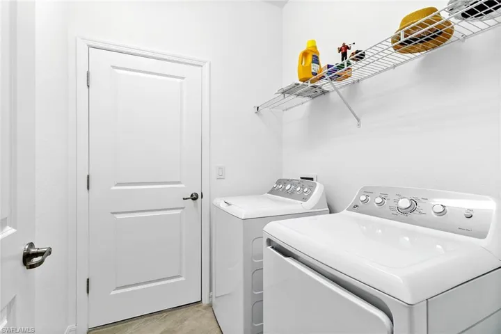 Dedicated laundry area featuring a white top-load washing machine and a white front-load dryer