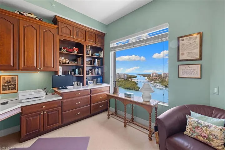 Office space with light colored carpet and built in desk