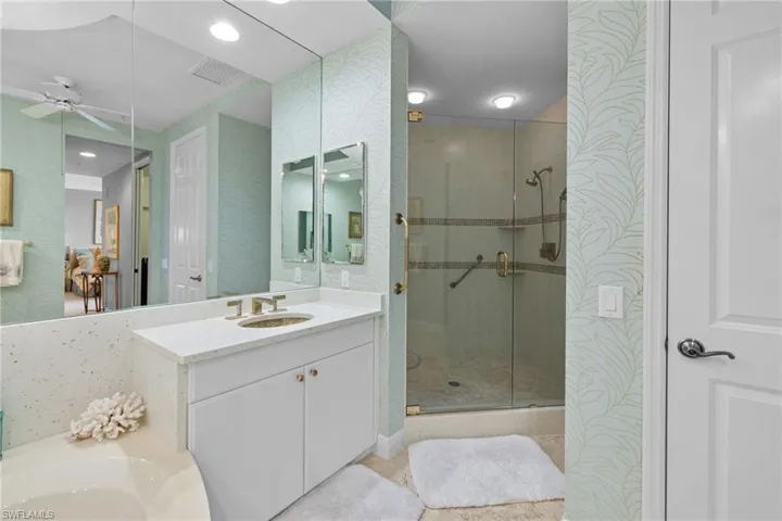 Bathroom with wallpapered walls, a stall shower, vanity, a ceiling fan, and recessed lighting