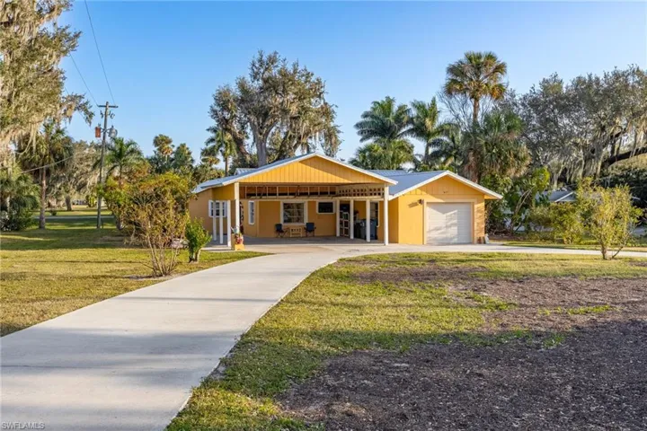 Ranch-style house featuring a front lawn and a carport