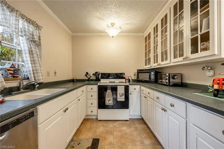 Kitchen featuring white cabinetry, dishwasher, sink, a textured ceiling, and electric stove