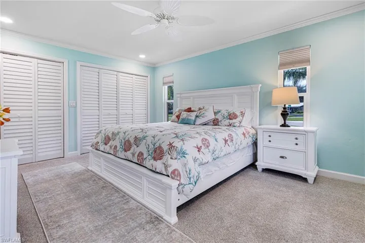 Bedroom featuring crown molding, light carpet, and ceiling fan