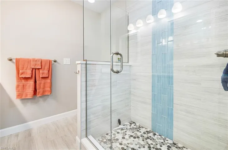 Bathroom with tile flooring and a shower with shower door