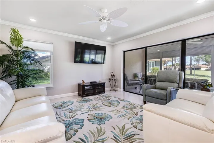 Living room with ceiling fan, plenty of natural light, and crown molding
