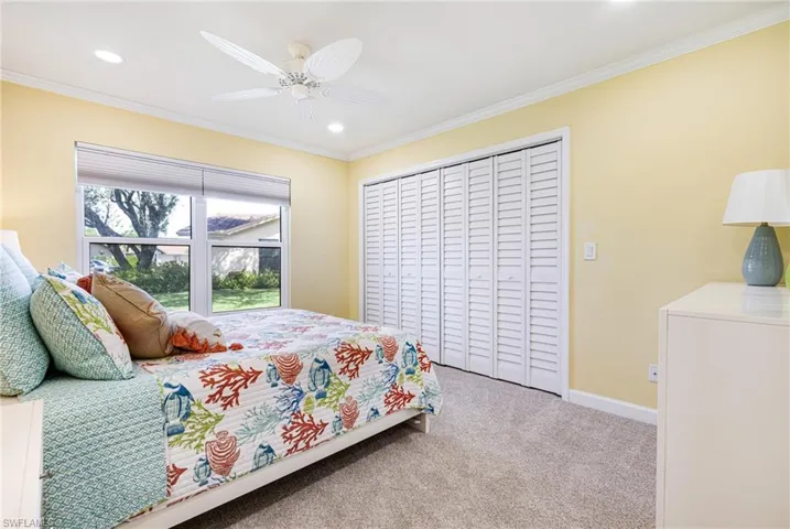 Bedroom featuring ceiling fan, light carpet, a closet, and ornamental molding